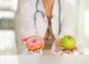 Help Prevent Diabetes With Michigan Apples (Doctor holding an apple in right hand, and a donut in left)
